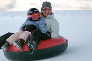 Mom and child snow tubing