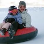 Mom and child snow tubing