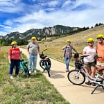 group on E-bikes with Flatirons behind them