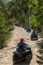 riders on ATV's riding along rugged trails