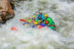 Colorado Rafting Company roaring thorugh Class III–IV rapids on Clear Creek
