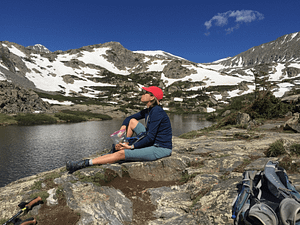 woman sitting near an alpine lake in Summit County Colorado