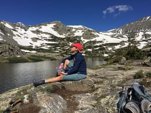 woman sitting near an alpine lake in Summit County Colorado